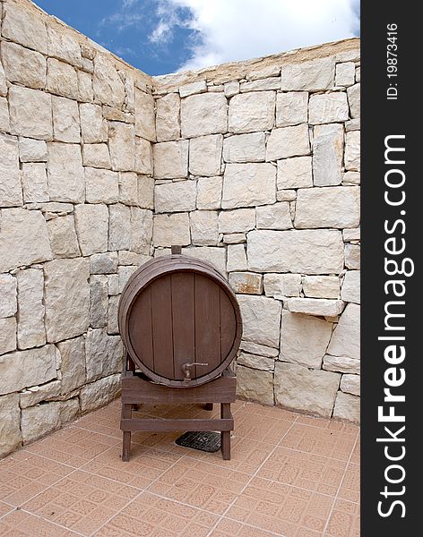 An old Wine Barrel in a Greek Courtyard under a blue summer Sky