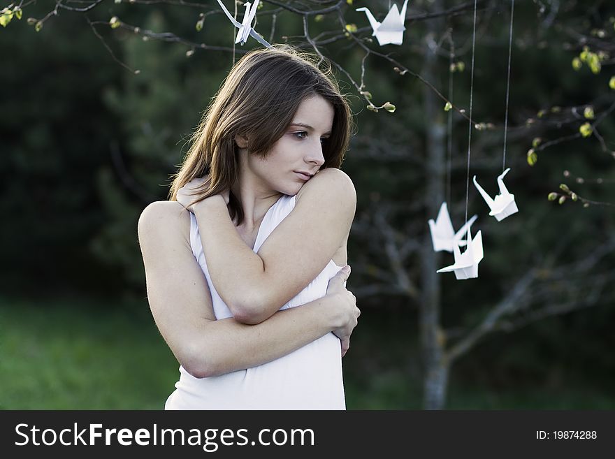 A portrait of a young woman standing in the park