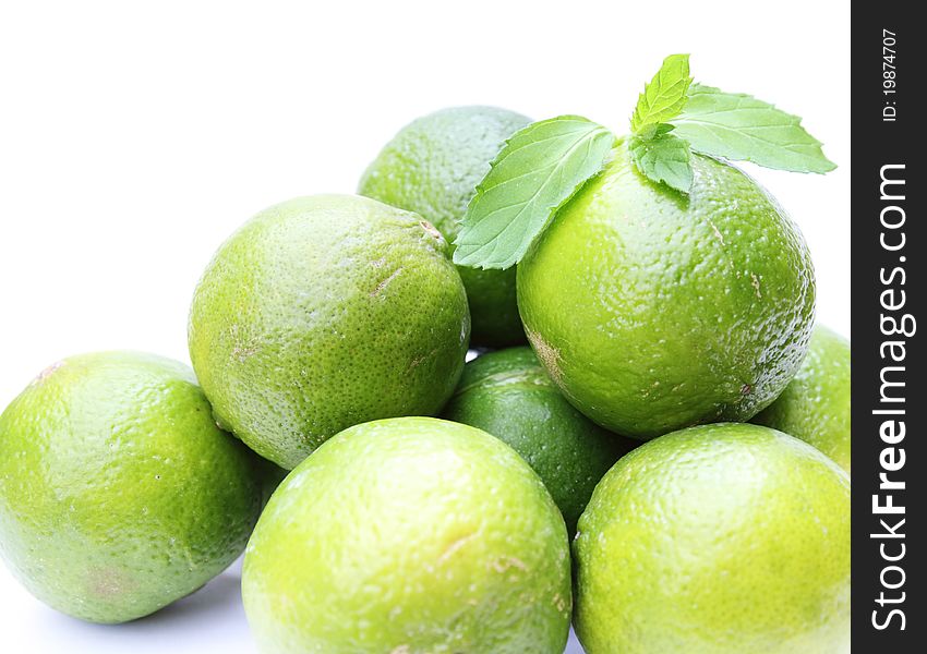 Fresh limes with mint isolated on white background