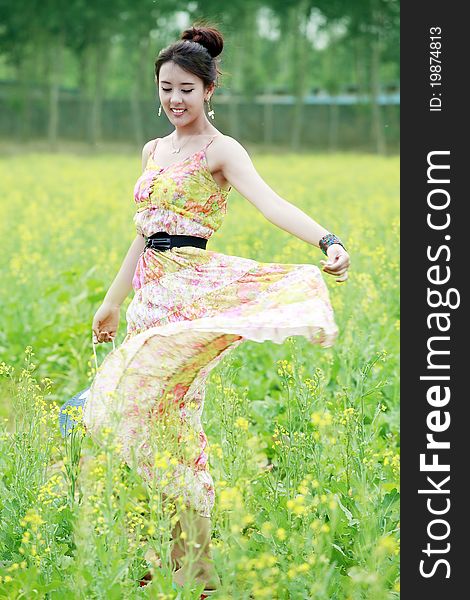 Charming Asian girl strolling in summer rape field. Charming Asian girl strolling in summer rape field.