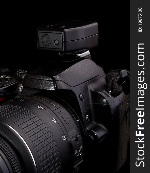 Black digital camera with wireless flash trigger on black