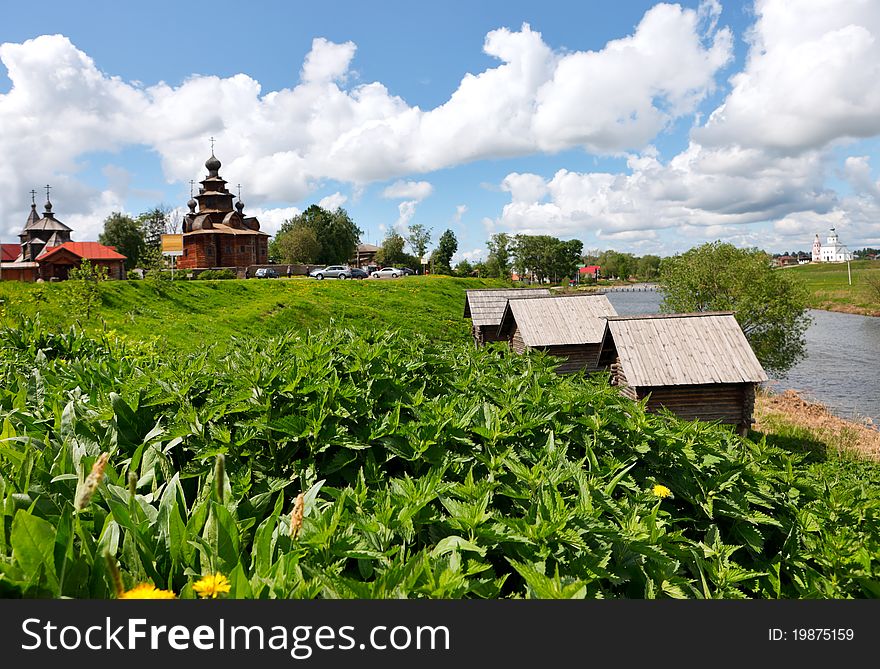 Bed of nettles at Kamenka river bank in ancient russian town Suzdal against old wooden church. Bed of nettles at Kamenka river bank in ancient russian town Suzdal against old wooden church.