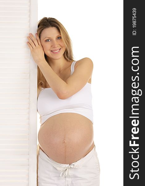 Happy pregnant woman standing near the door isolated on white