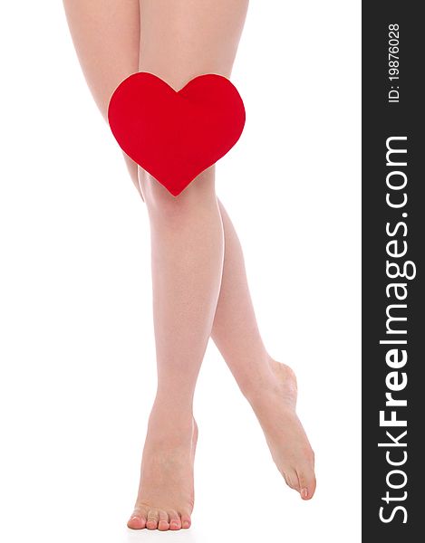 Female legs with red heart isolated on white