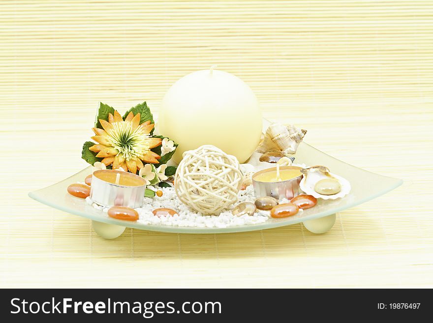 Home decoration with candle and artificial flower on decorative glass plate