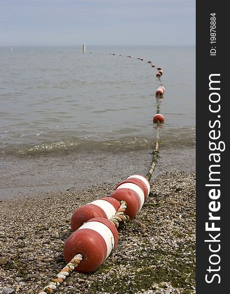 A line of buoys marking the swimming area at a beach. A line of buoys marking the swimming area at a beach.