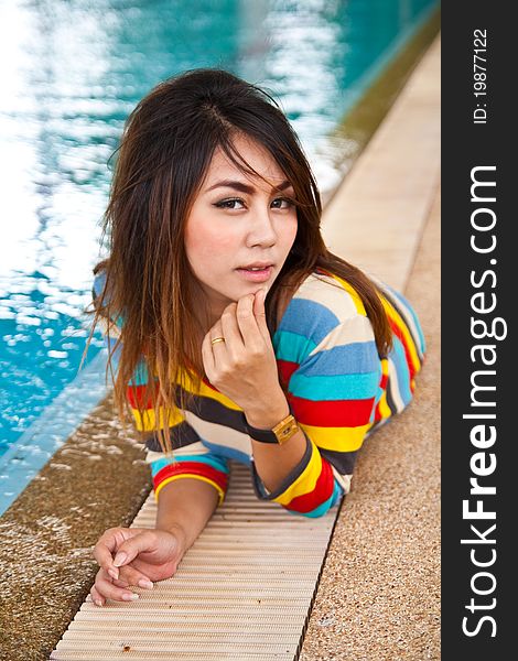 Young woman relaxing beside swimming pool.