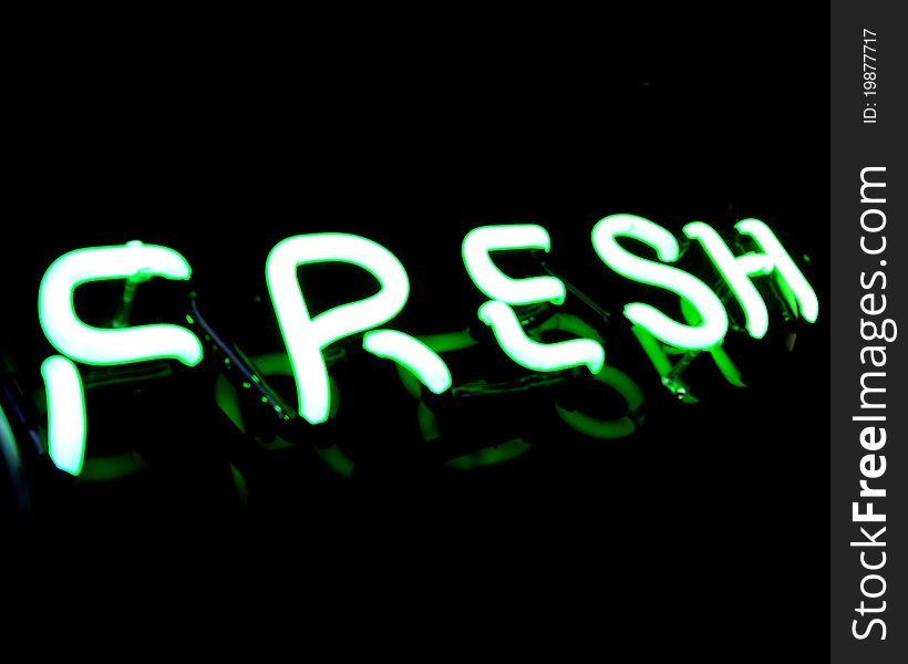 Green Fresh neon sign on black background, captured at late-night grocery store