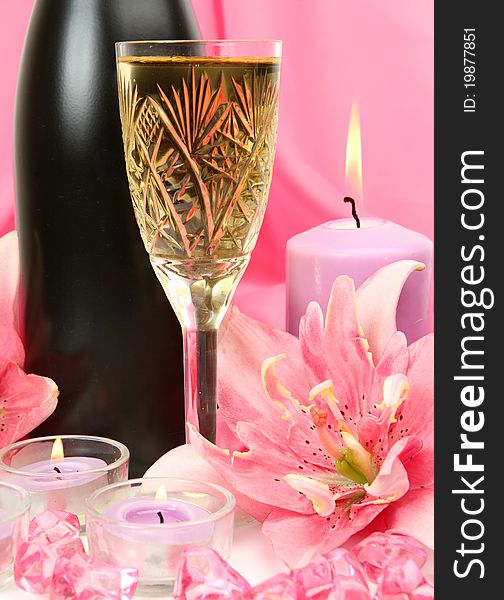 Wine and candles on a pink background