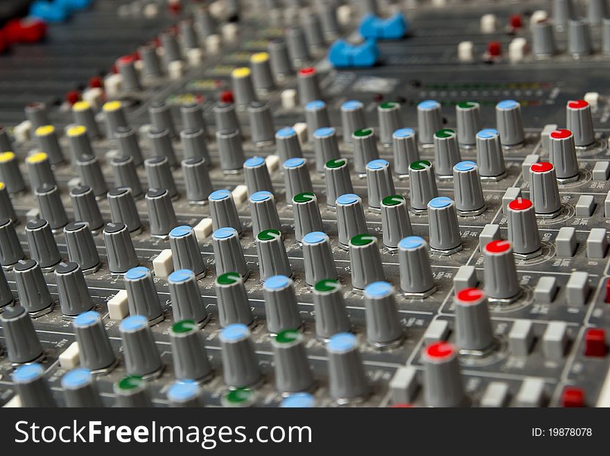 Audio mixing console in a recording studio. Faders and knobs of a sound mixer. Audio mixing console in a recording studio. Faders and knobs of a sound mixer.