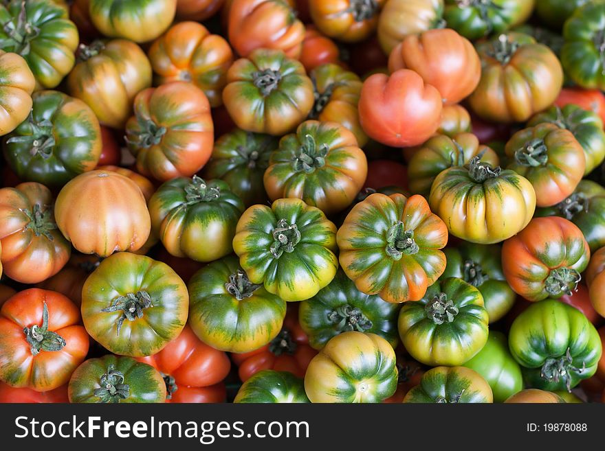 Fresh Italian Costoluto tomatoes on display at an outdoors farmers' market stall