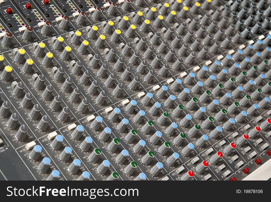 Audio mixing console in a recording studio. Faders and knobs of a sound mixer. Audio mixing console in a recording studio. Faders and knobs of a sound mixer.