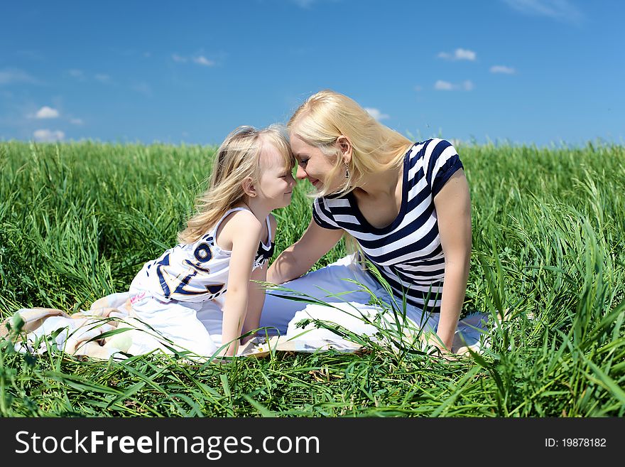 Mother with her daughter outdoors in summer day