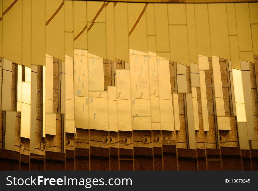 A Building is mirrored in the opposite glass wall, falling into many parts and forming abstract images, like city skyline. A Building is mirrored in the opposite glass wall, falling into many parts and forming abstract images, like city skyline.