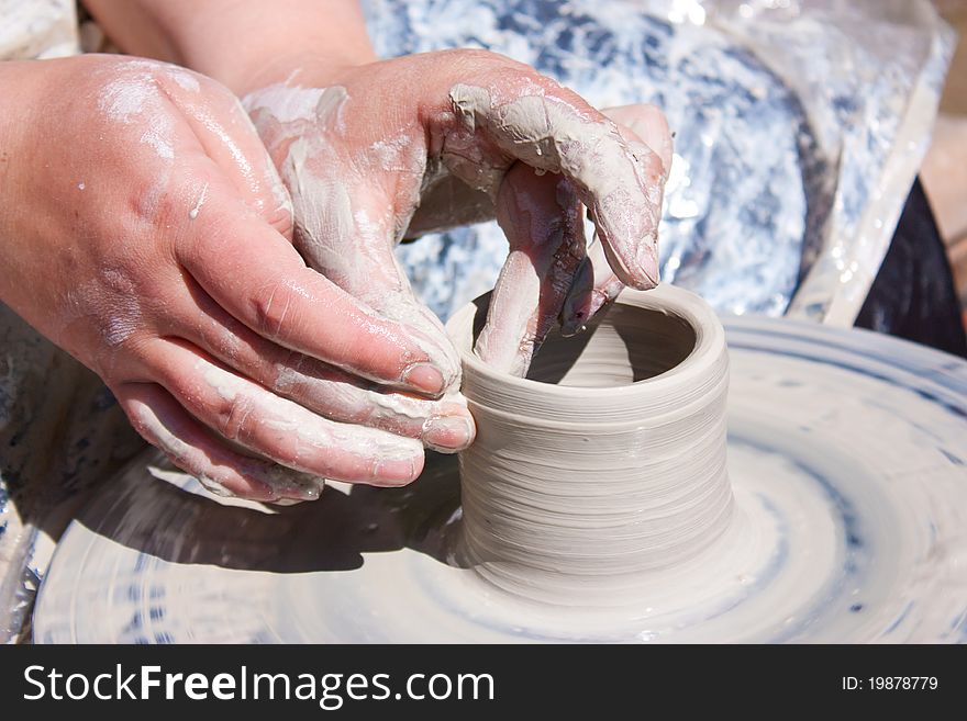 Potter hands working on pottery wheel