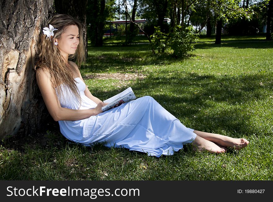 Young woman reading book in park