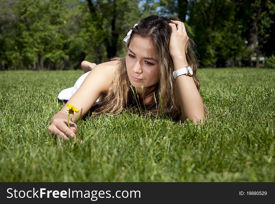 Portrait of the young woman lying on a grass in summer. Portrait of the young woman lying on a grass in summer