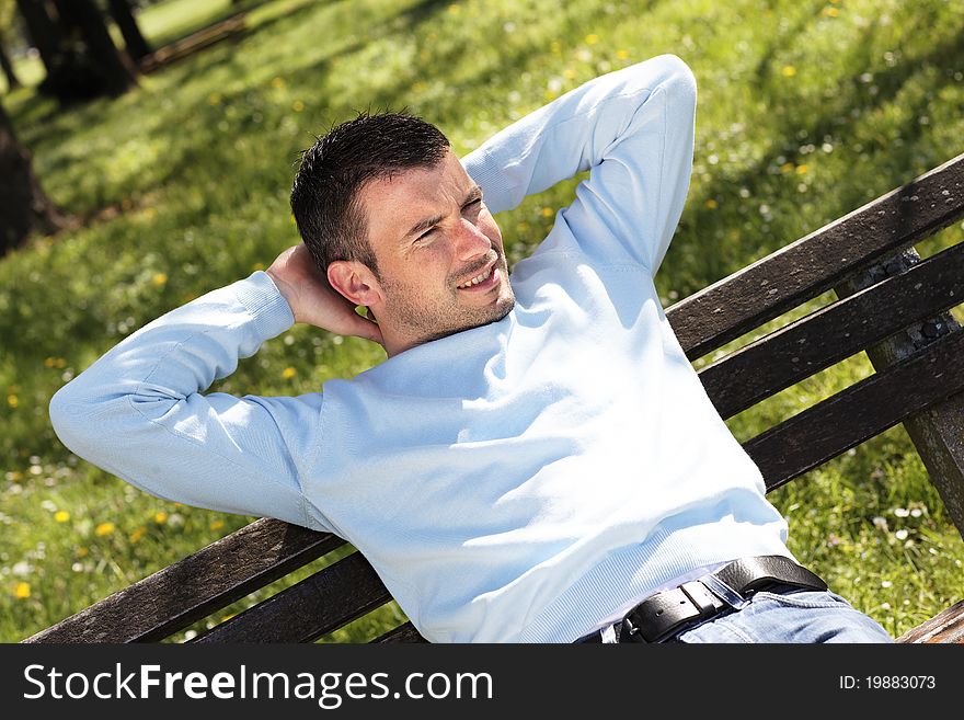 Relaxed man on a bench in a park. Relaxed man on a bench in a park