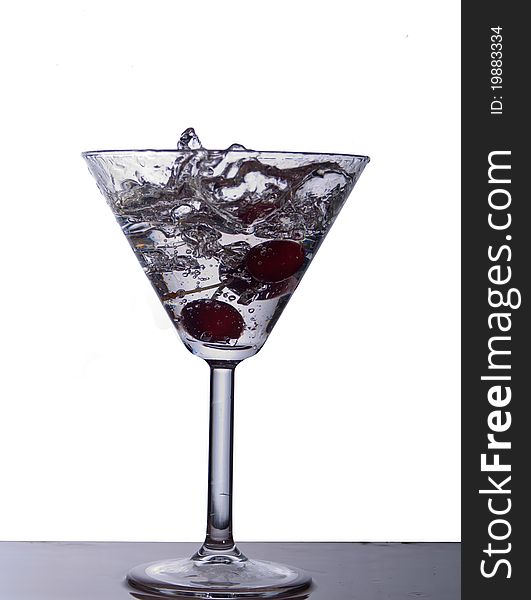 Isolated coctail with cherry spash in clear water. Isolated coctail with cherry spash in clear water