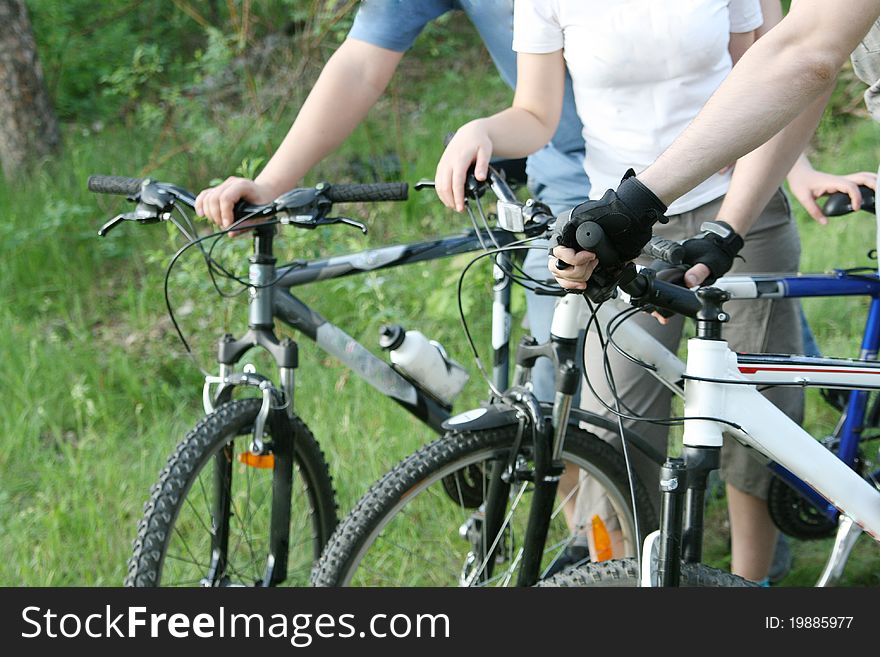 Three cyclists resting on bikes