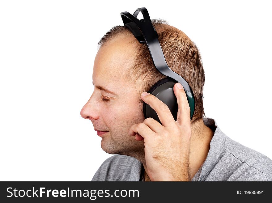 Young man listening to the music in headphones isolated on white. Young man listening to the music in headphones isolated on white