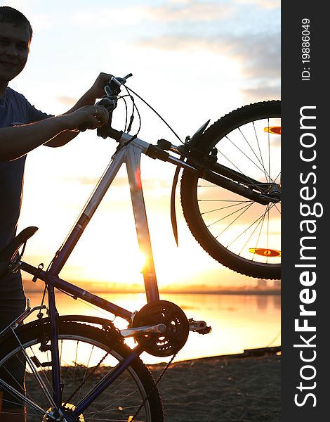 Silhouette of a cyclist on the background of the lake