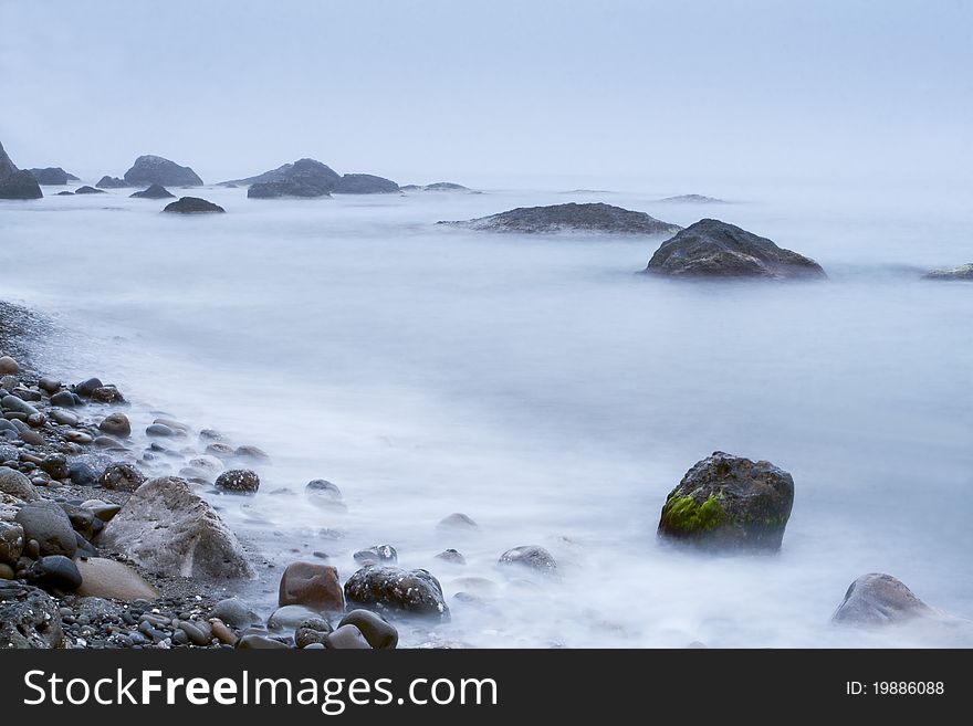 Morning sea shore with surf and rocks