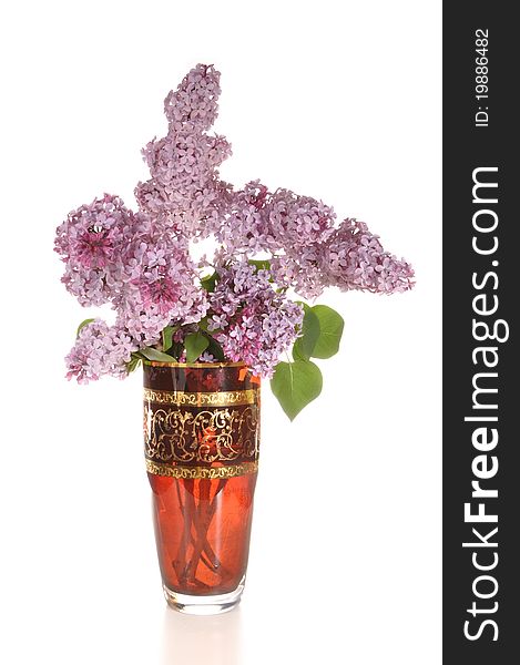 The blossoming lilac costs in a glass vase. The blossoming lilac costs in a glass vase