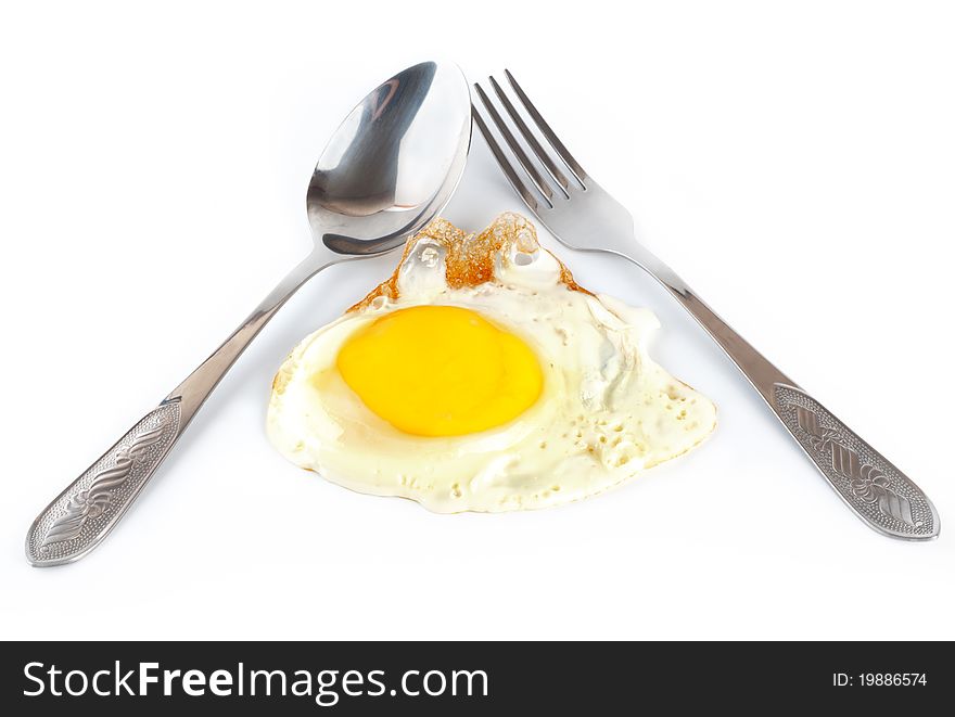 Fried egg with a spoon and fork on white background