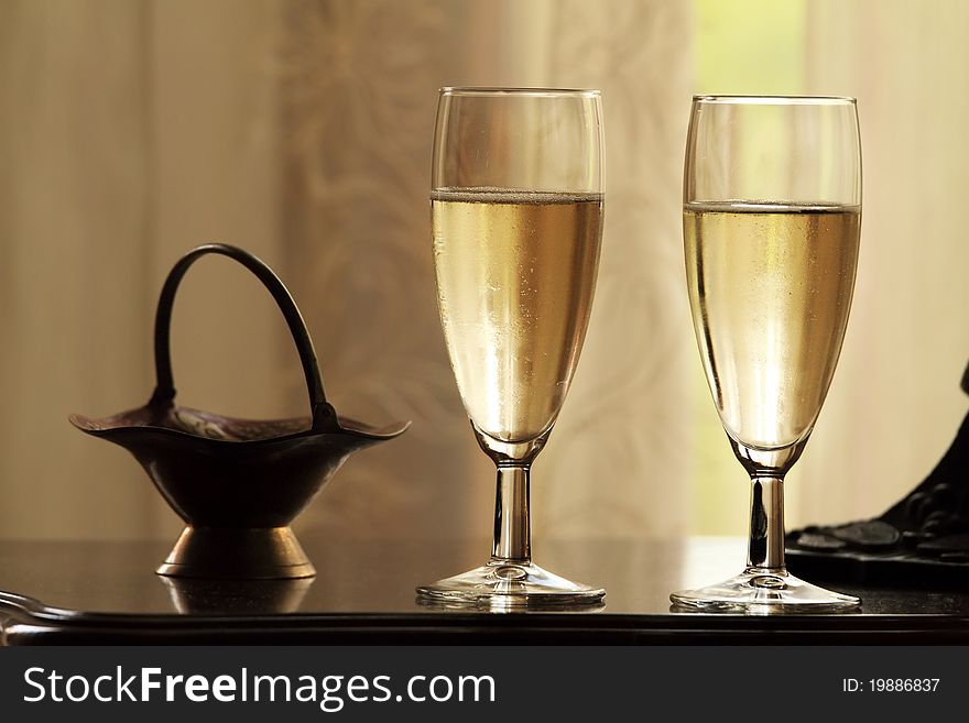 Two glasses of champagne on abstract yellow background