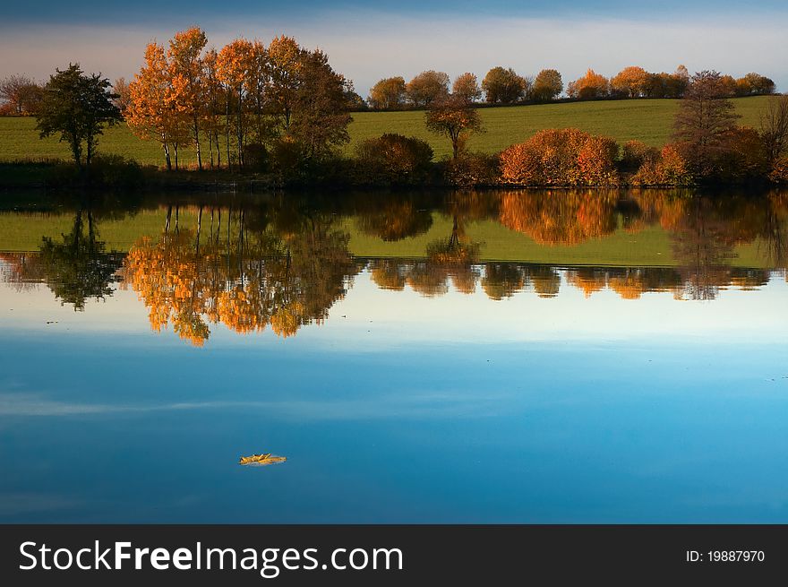 Autumn pond behind sunny weather.