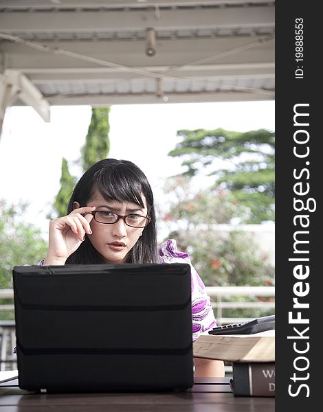 Young asian woman with glasses working outdoor. Young asian woman with glasses working outdoor