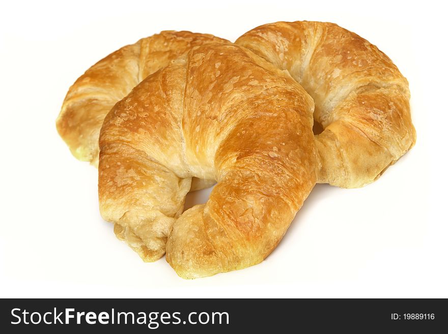 Three croissants, isolated on white with soft shadow.