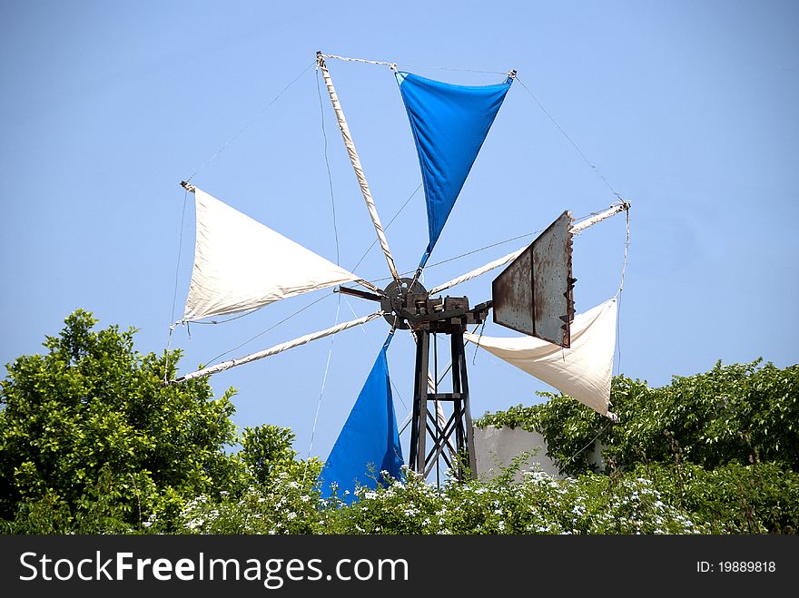 The Sails of a Greek Windmill surrounded by Jasmine Flowers
