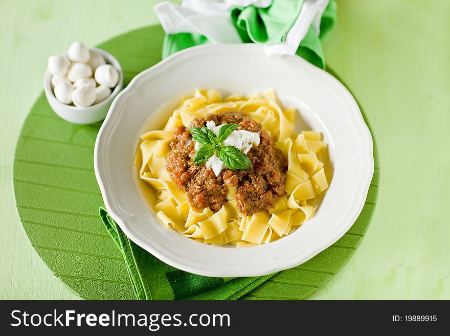 Delicious pasta with tomato meat sauce and mozzarella chips over it