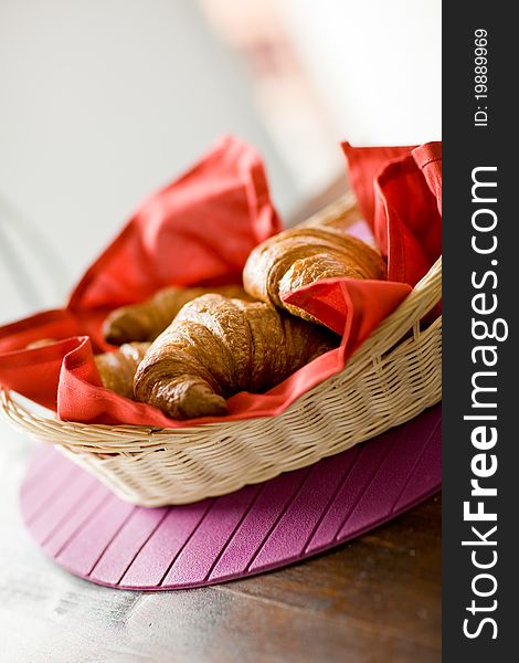 Photo of delicious warm and fresh croissants on wooden table by daylight