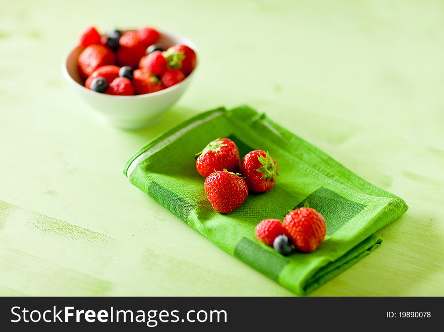 Photo of mixed fresh berries on green table by day light