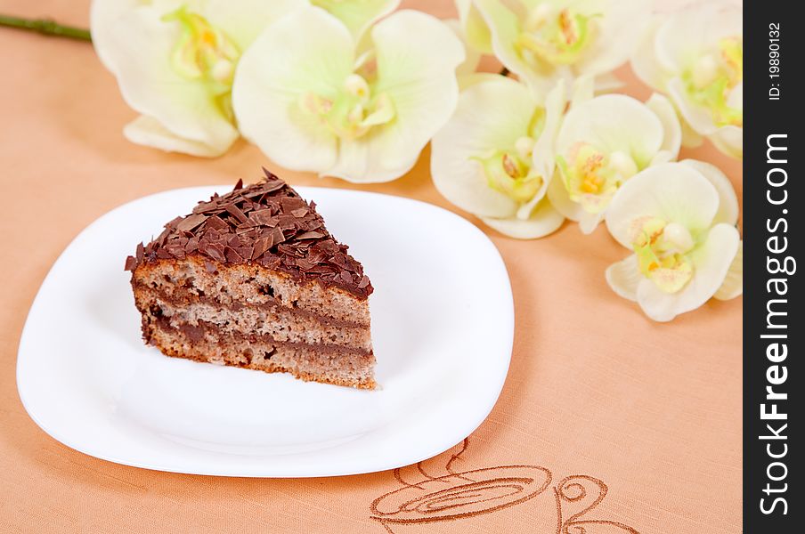 Chocolate cake on white plate and orchid