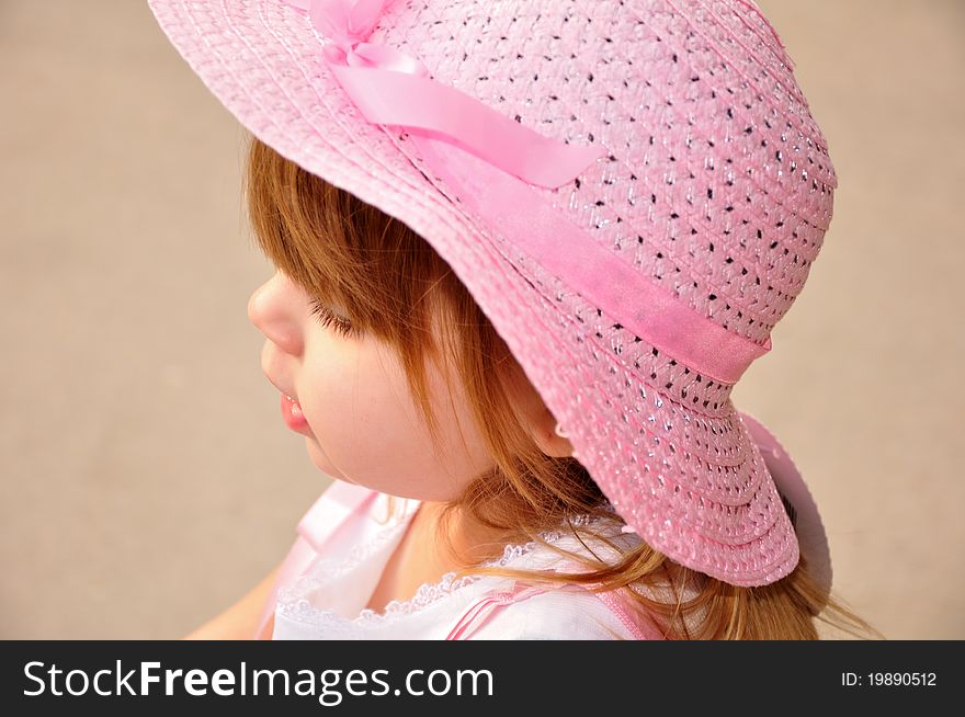 Toddler wearing a pink hat while thinking of her next step. Toddler wearing a pink hat while thinking of her next step.