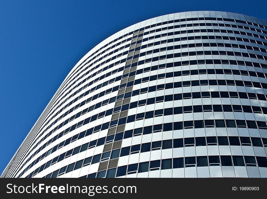 Curved futuristic office building reaches towards the sky. Curved futuristic office building reaches towards the sky.