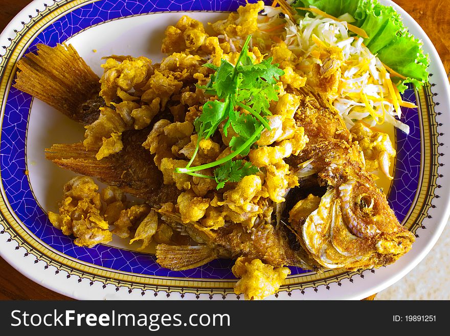 Fried fish and fried garlic on the dish. Fried fish and fried garlic on the dish.