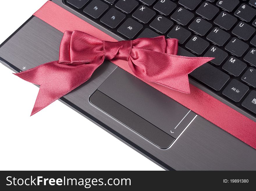 Personal computer as a gift tied with a red ribbon with a bow. Personal computer as a gift tied with a red ribbon with a bow.