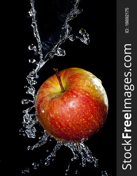 Fresh apple and water splash over black background. Fresh apple and water splash over black background