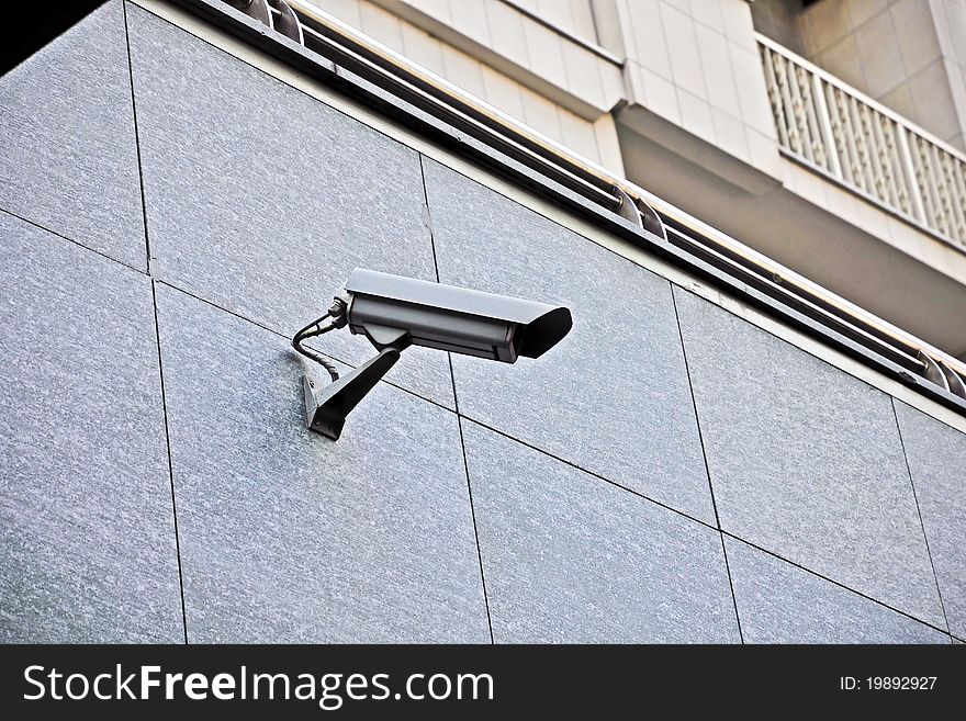 Surveillance camera - A surveillance camera mounted on a wall to control a public place.