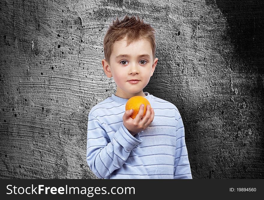 Portrait of a child with an orange.Outdoor