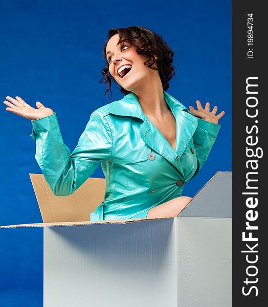 Beautiful woman coming out of cardboard box making surprise. Beautiful woman coming out of cardboard box making surprise