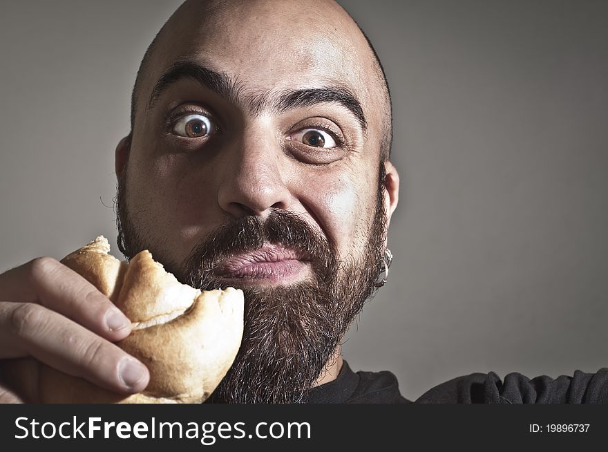 Man with bread in his mouth on grey background