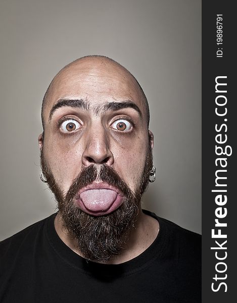 Man showing his tongue on grey background