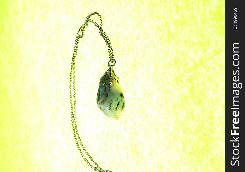 A precious stone pendant on a gold necklace. A precious stone pendant on a gold necklace