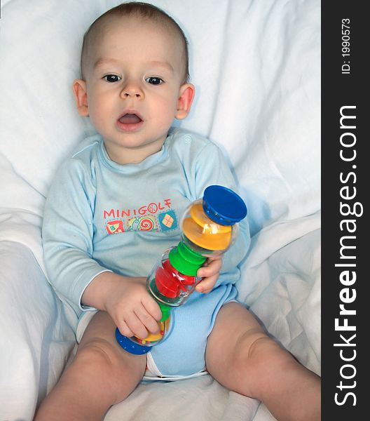 The kid of 7 months sits with toy. The kid of 7 months sits with toy